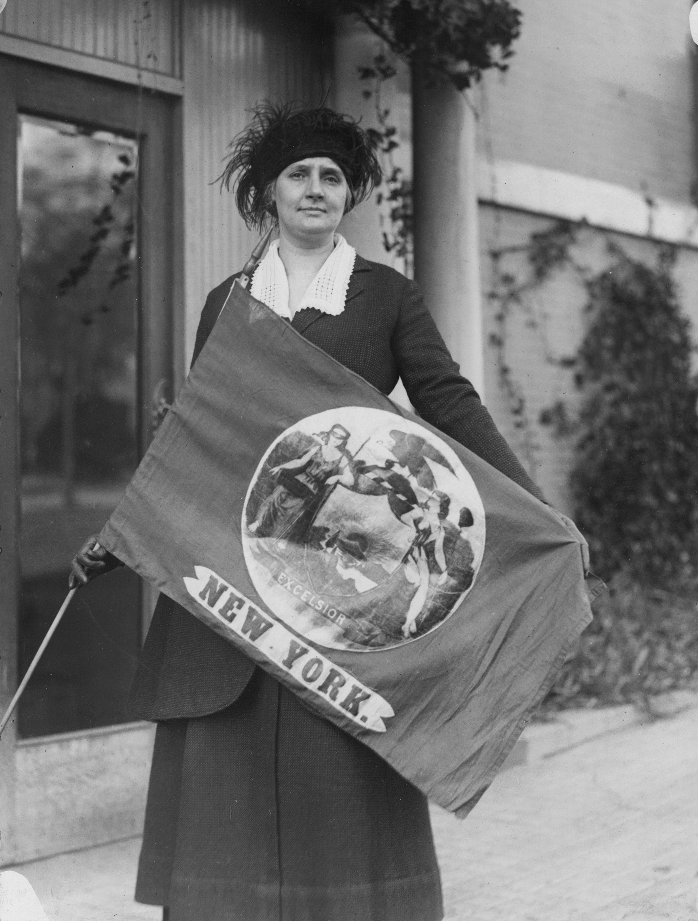 In this photo from February 1921, Ainge proudly displays the New York State flag as she arrives for the first convention of the National Woman’s Party following the amendment’s ratification. Ainge was the first of the delegates to arrive at the four-day event in Washington. Retrieved from the collection of the Library of Congress, http://hdl.loc.gov/loc.mss/mnwp.147004.